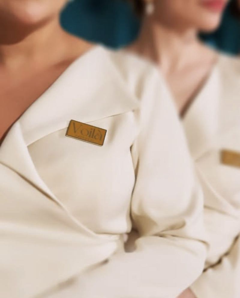 Close view of the gold Voil&agrave; badge on the cream uniform