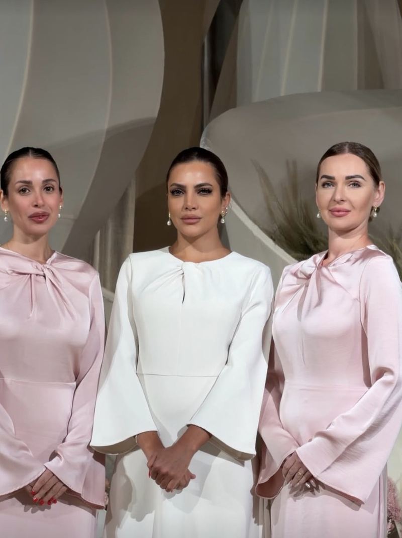 Three Voil&agrave; Protocol hostesses in the venue lobby, in blush and ivory
