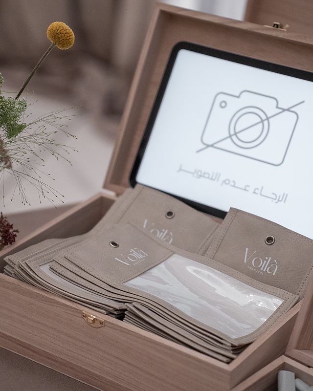The privacy box open: the no photography sign on the tablet, the Voil&agrave;-stamped phone pouches ranged beneath it