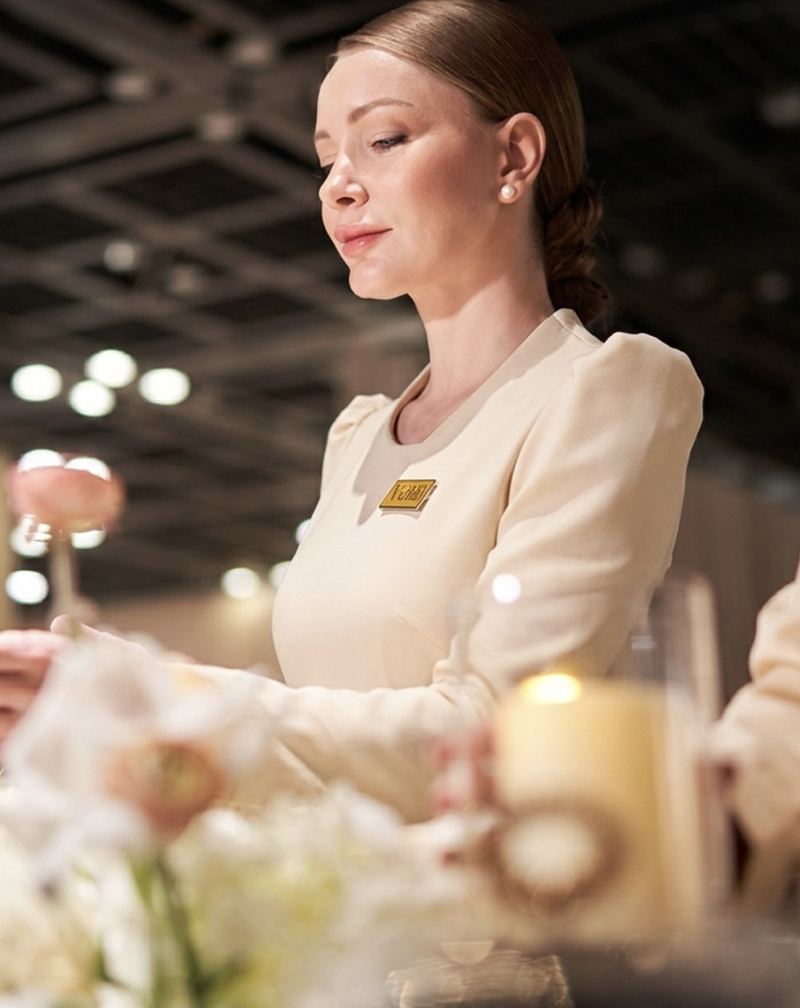 A Voil&agrave; Protocol hostess arranging the flowers on a guest table